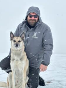 A man with his husky dog.