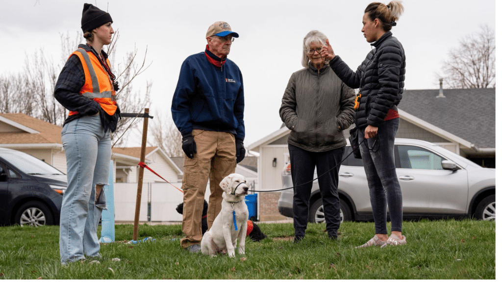 A group of Trainors and a white dog